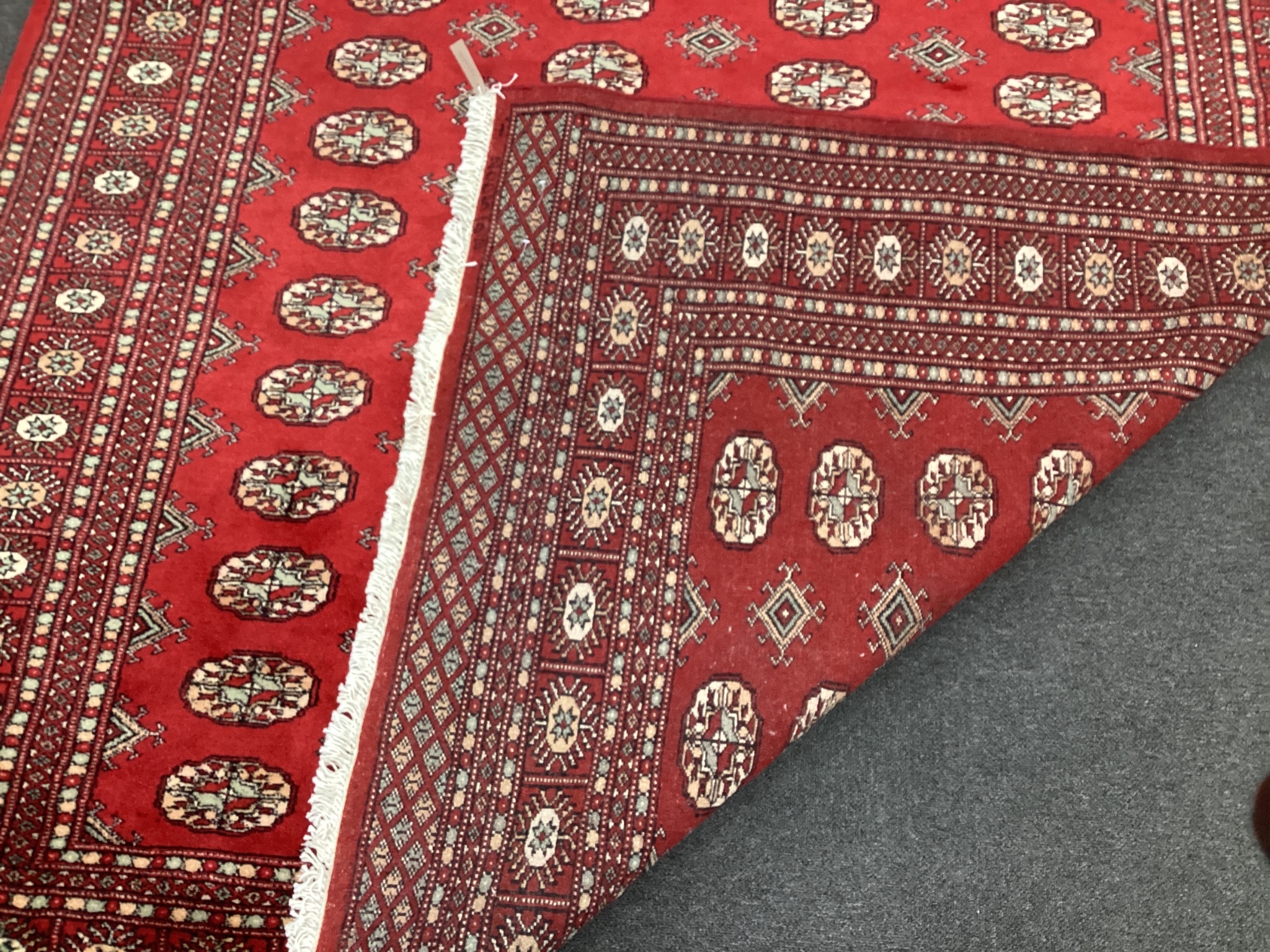 A Bokhara style red ground carpet, 280cm x 188cm